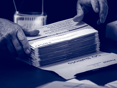 hands stacking ballots